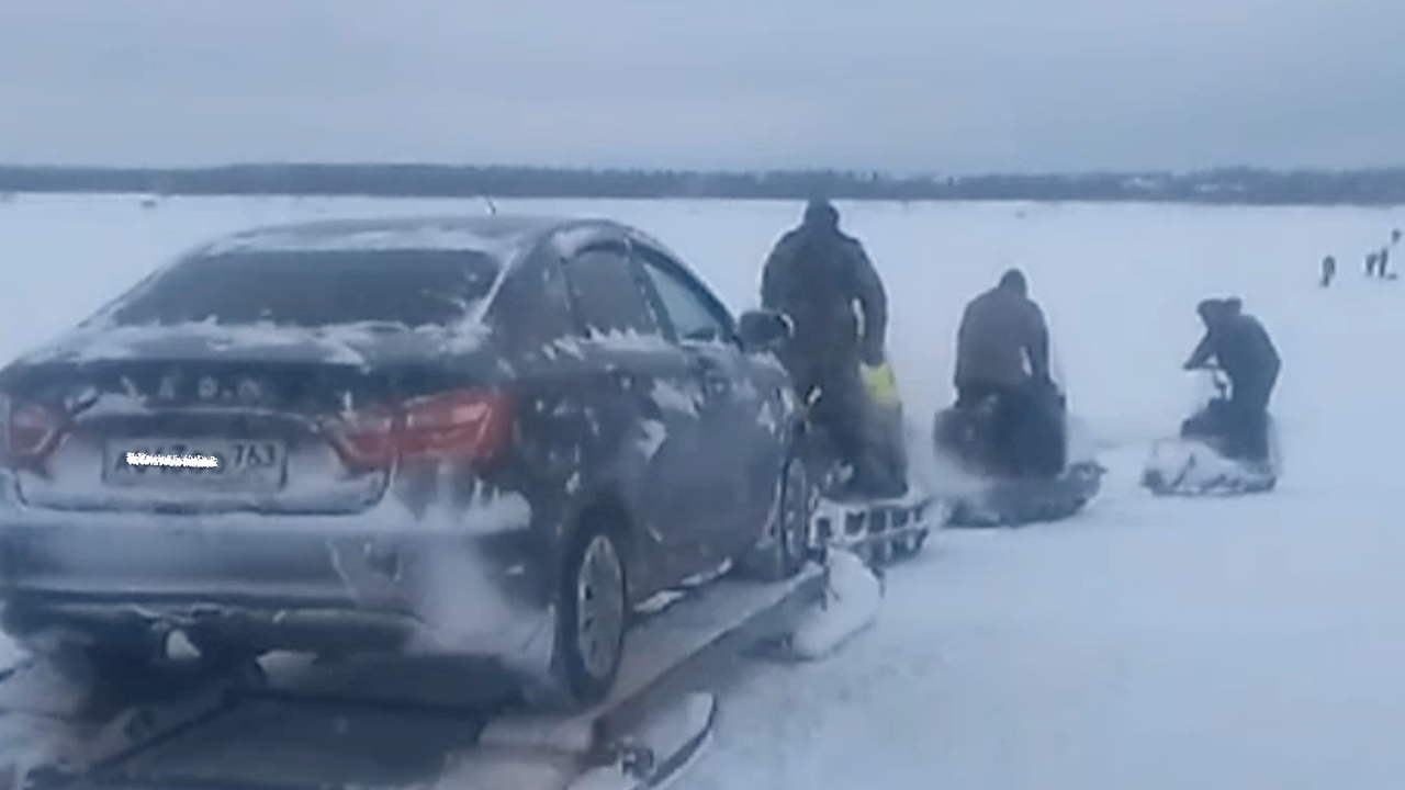 Главная картинка новости: Смельчаки перевозят машины с помощью снегоходов через закрытую переправу на Печоре