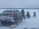Смельчаки перевозят машины с помощью снегоходов через закрытую переправу на Печоре